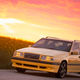 A photo of a yellow Volvo 850R station wagon at sunset.